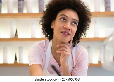 A Beautiful Saleswoman In An Ice Cream Parlor Writes Down An Order.