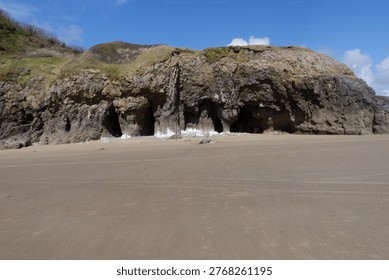 The beautiful sandy beach, with cliffs in the background, at Pendine, Carmarthenshire, Wales, UK.
