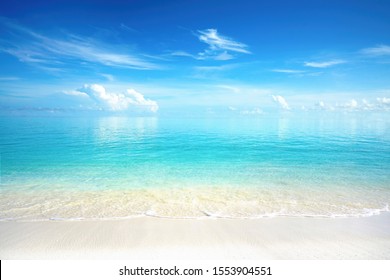 Beautiful sandy beach with white sand and rolling calm wave of turquoise ocean on Sunny day. White clouds in blue sky are reflected in water. Maldives, perfect scenery landscape, copy space. - Shutterstock ID 1553904551