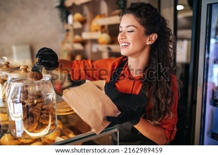Beautiful and satisfied woman working in bakery.
