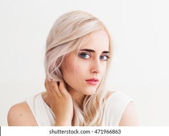 Beautiful scandinavian woman portrait, close-up. Attractive blue-eyed blonde girl, looking at camera, close-up, white background