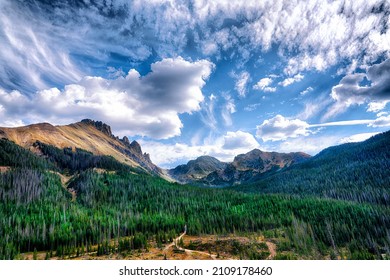 A beautiful scene of a forest with Nokhu Crags mountains in the background with cloudy skies - Shutterstock ID 2109178460