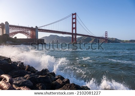 A beautiful scene of the Golden Gate Bridge Presidio USA over water with a blue light sky