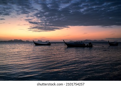 Beautiful scene of seascape after the sunset time. Very nice dark clouds with the a silhouette of a long tail boats in the background.