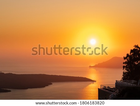 A beautiful scene of the sun set, as seen from a vantage point from the village of Fira, on the island of Santorini in Greece.