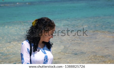 Beautiful scene of a woman walking on ocean beach. Young barefoot girl along the surf line