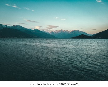 A beautiful scenery of a calm lake surrounded by hills under the cloudy sky