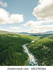 A Beautiful Scenery Of A Curvy Road Surrounded By Green Tree Forests In Norway