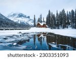 Beautiful scenery of Frozen Emerald Lake with wooden lodge in pine forest on winter at Yoho national park, Alberta, Canada