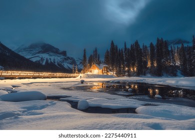 Beautiful scenery of Frozen Emerald Lake with wooden lodge glowing in snowfall on winter at the night in Yoho national park, Alberta, Canada - Powered by Shutterstock