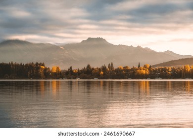 Beautiful scenery of golden sunrise over mountain range and autumn forest on Lake Wanaka at New Zealand - Powered by Shutterstock