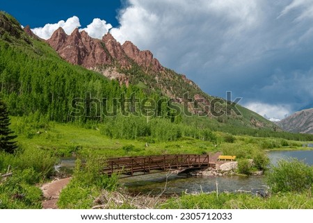 A beautiful scenic footbridge over West Maroon Creek beneath the famous Maroon Bells near Aspen Colorado.
