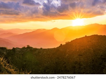 beautiful scenic sunset landscape of a canyon between two mountains with green  bush rocks on foreground and amazing walley with bright cloudy sky on background - Powered by Shutterstock