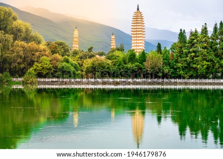 Beautiful scenic view of Dali Three Pagodas of Chongsheng Temple with water reflection and dramatic light in Dali Yunnan China