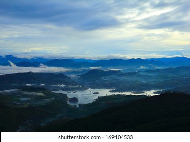 Beautiful scenic view at early morning - shadow figures of fogged mountain tops and serene lake against the background of dramatic blue sky near Sri Pada (Adam's Peak), Sri Lanka island, South Asia  - Powered by Shutterstock