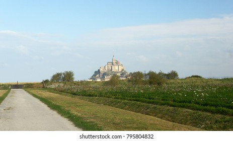 Beautiful scenic view of famous historic Le Mont Saint-Michel tidal island with fields in the morning, an UNESCO world heritage site, Normandy, northern France