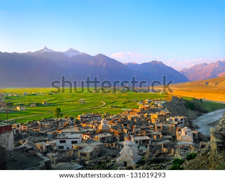 Beautiful scenic view of Padum city with traditional Tibet houses against the background of green field and purple mountain in Zanskar valley on evening, Ladakh range, Jammu & Kashmir, Northern India
