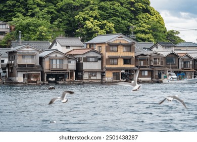 Beautiful scenic view with the wooden traditional waterfront boat houses called funaya around Ine Bay, in the village Ine, Japan - Powered by Shutterstock