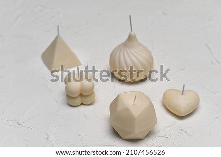 beautiful scented candles on a white plastered background.
