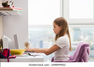 Beautiful School Girl Sit At Desk In Good Posture. Large And Bright Window In Background.