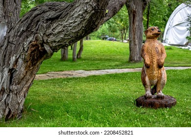 Beautiful Sculpture Made Of Wood On A Green Meadow. Ferret, Gopher, Badger, Meerkat