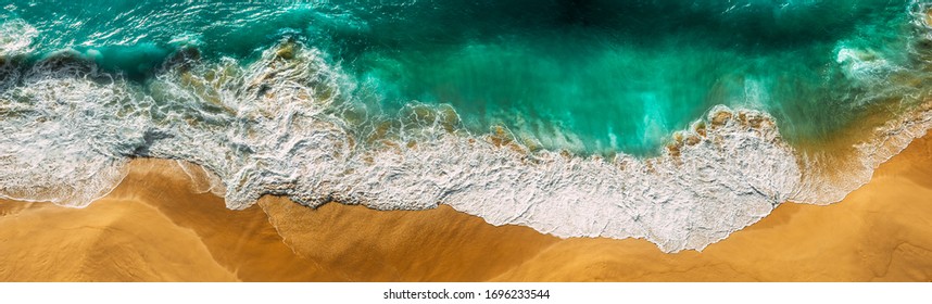 Beautiful sea wave at sunset from a bird's eye view. Beautiful lonely beach at sunset. Aerial view of turquoise ocean waves in Kelingking beach, Nusa penida Island in Bali, Indonesia. Beaches of Bali