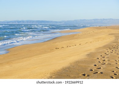 Beautiful Seascape. Blue Ocean, Silhouette Of Mountains, And Wide Sandy Beach With Foot Prints, California Central Coast