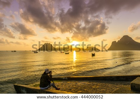 beautiful seascape in early morning with woman photographer.