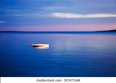 Beautiful Seascape with Lonely White Boat Floating in Blue Sea at Sunset. Peaceful Background with Tranquil Calm Water and Reflection. Copy Space. - Powered by Shutterstock