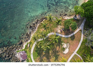 Beautiful seashore with coral, rocks, sand, light blue summer beach, coast, seawater, coral reef, coco palm. Beautiful top view of tropical and natural background. Tanjung Lesung, Banten, Indonesia.  