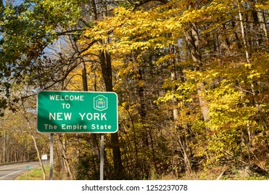 Beautiful seasonal fall color over the highway sign that welcomes travelers to New York
