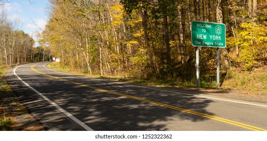 Beautiful seasonal fall color over the highway sign that welcomes travelers to New York