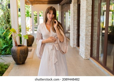 Beautiful  Seductive Woman Stand On Balcony Terrace Of Jungle Villa Wearing  Silk Bathrobe. Vacation On Tropical Island.