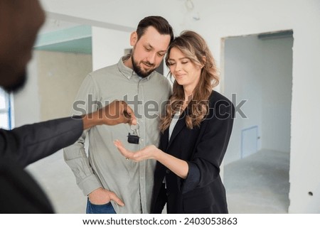Beautiful self made woman buisnesswoman buying a new house for family receiving keys hugging with beared husband man the house is sold out.Homeowners real estate property purchase renting apartment.