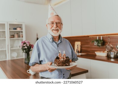 Beautiful senior couple celebrating  anniversary with birthday cake - Elderly couple having birthday party at home - Powered by Shutterstock