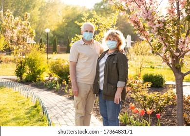 Beautiful Senior Couple In Love Wearing Medical Mask To Protect From Coronavirus Outside In Spring Or Summer Nature