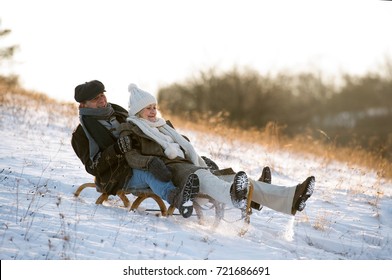 Beautiful Senior Couple On Sledge Having Fun, Winter Day.