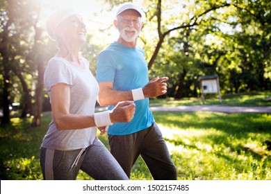 Beautiful Senior Couple Running Outside In Forest