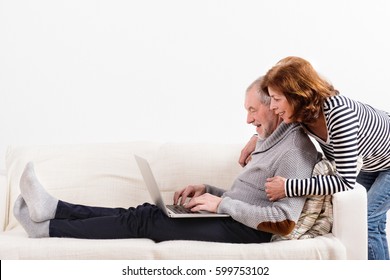 Beautiful Senior Couple Working On Laptop. Studio Shot.