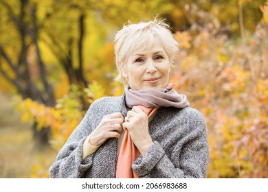 Beautiful Senior Lady Posing Against The Background Of A Bright Autumn Tree. Outside. Concept Of Active Lifestyle Of Pensioner, Insurance, Happy Old Age, Grandmother. Caucasian Woman 65 Years Old