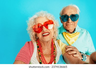 Beautiful senior old couple wearing fancy party clothes acting in studio on a colored background. Conceptual image about third age and seniority, old people feeling young inside. - Powered by Shutterstock