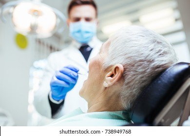 Beautiful Senior Woman At Dentist Having Dental Treatment At Dentist's Office.