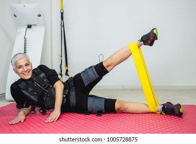Beautiful senior woman doing exercises in electrical muscular stimulation suit.