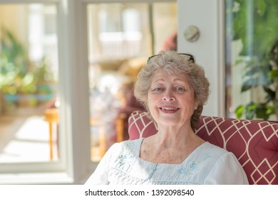 A beautiful senior woman enjoys her morning rituals on a sunny porch in her home. - Powered by Shutterstock