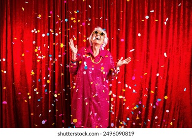 Beautiful senior woman with gray hair wearing colorful stylish clothing portrait in studio - Cheerful old grandmother with fashionable style celebrating with confetti at birthday party - Powered by Shutterstock