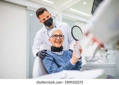 Beautiful Senior Woman Having Dental Treatment At Dentist's Office. Dentist Is Wearing Protective Face Mask Due To Coronavirus Pandemic.	