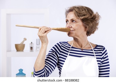 Beautiful senior woman tasting the soup - Powered by Shutterstock