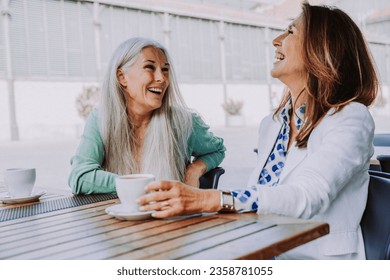 Beautiful senior women bonding outdoors in the city - Attractive cheerful mature female friends having fun, shopping and bonding, concepts about elderly lifestyle - Powered by Shutterstock