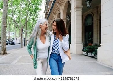 Beautiful senior women bonding outdoors in the city - Attractive cheerful mature female friends having fun, shopping and bonding, concepts about elderly lifestyle - Powered by Shutterstock