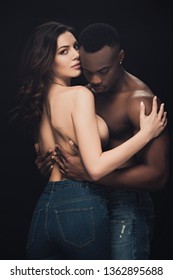 beautiful sensual half-naked interracial couple embracing isolated on black